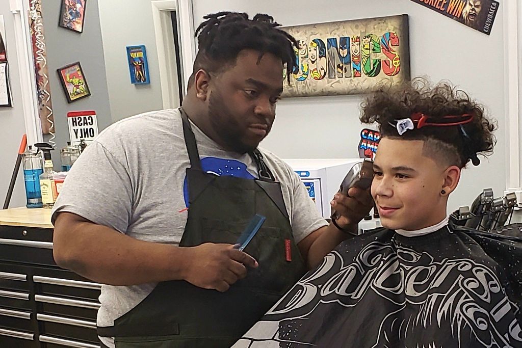 Barber giving kid a haircut at Damon's Cuts